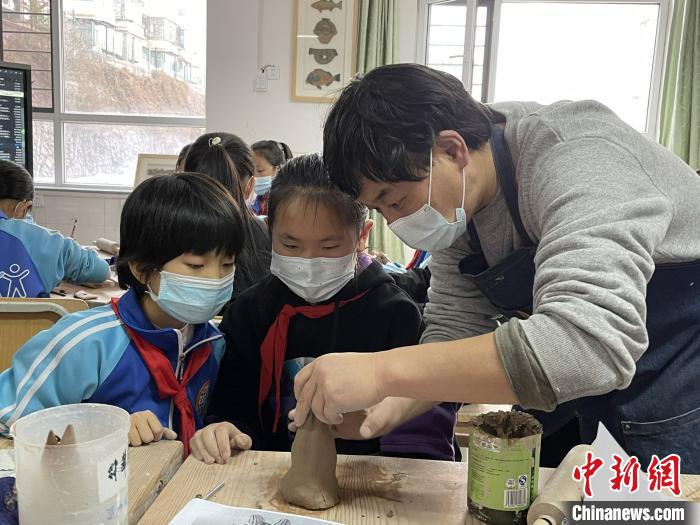 圖為西寧市勞動(dòng)路小學(xué)教師賈煜與學(xué)生一起制作陶藝?！≈苋鸪阶?攝
