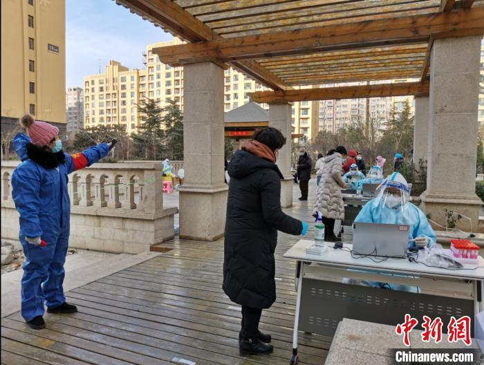 圖為社區(qū)工作人員在維持秩序?！∏谌A 攝