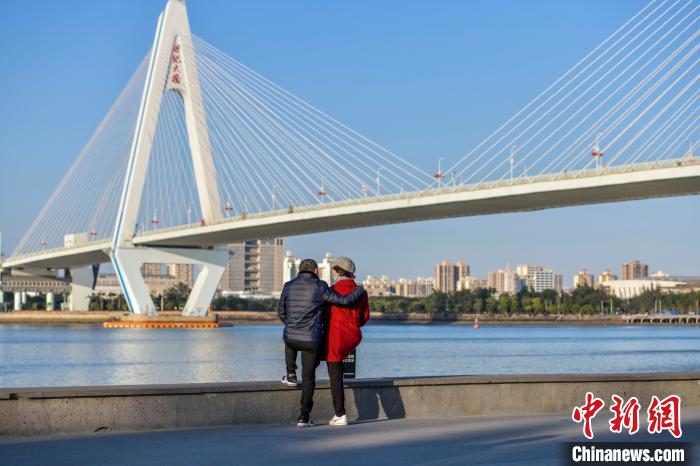 圖為一對情侶在海口灣享受冬日暖陽?！●樤骑w 攝