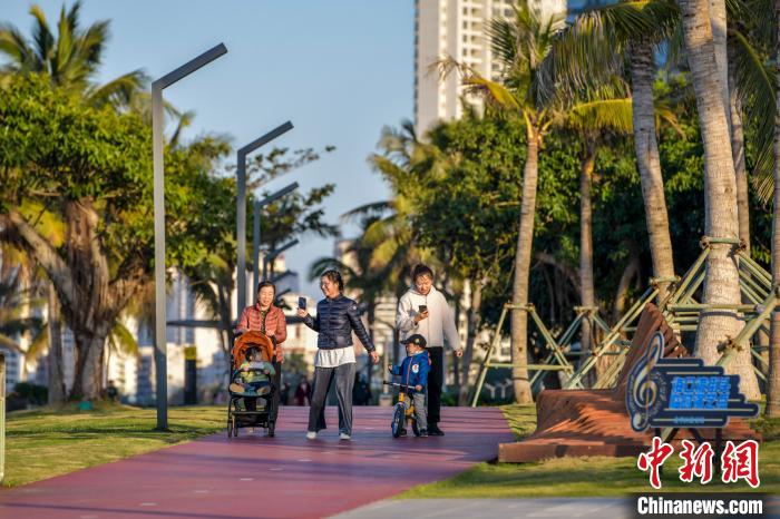 圖為海口市民漫步在?？跒常瑯废砭眠`陽光?！●樤骑w 攝