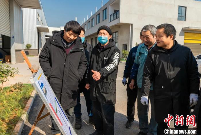 員工圍在展板前了解就地過(guò)年相關(guān)政策。婺城宣傳部供圖