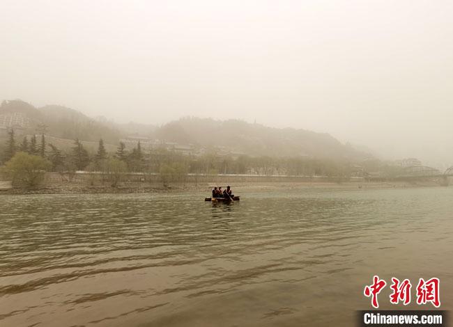 3月16日傍晚，黃河蘭州段被沙塵籠罩，遠(yuǎn)山和建筑若隱若現(xiàn)。(資料圖) 馮志軍 攝
