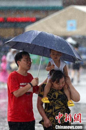 市民冒雨前行?！°蟛?攝