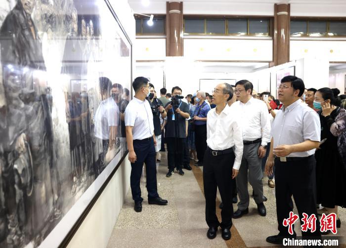 全國人大常委會(huì)副委員長、民革中央主席萬鄂湘等出席開幕式人士參觀展覽作品?！∶窀镏醒牍﹫D