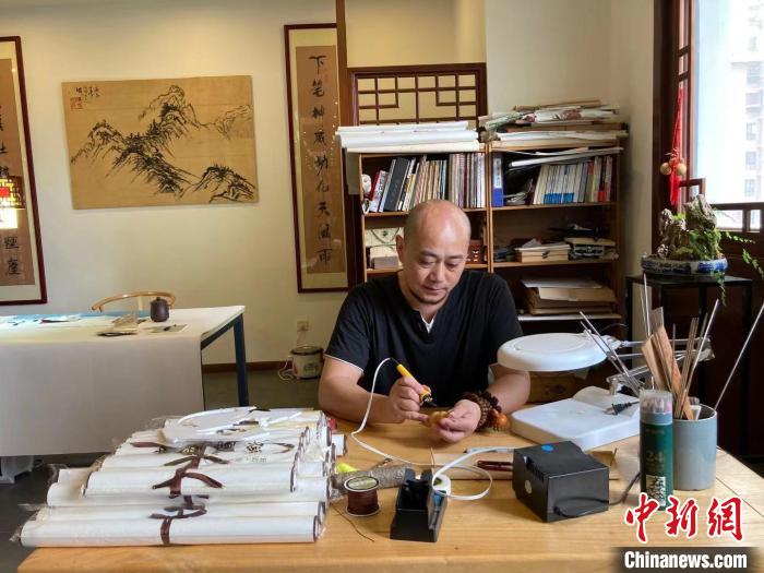 陶思俊正在進(jìn)行葫蘆烙畫(huà)創(chuàng)作?！￡愳o 攝