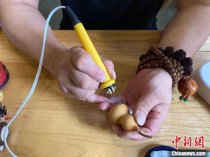 陶思俊正在進(jìn)行葫蘆烙畫(huà)創(chuàng)作?！￡愳o 攝