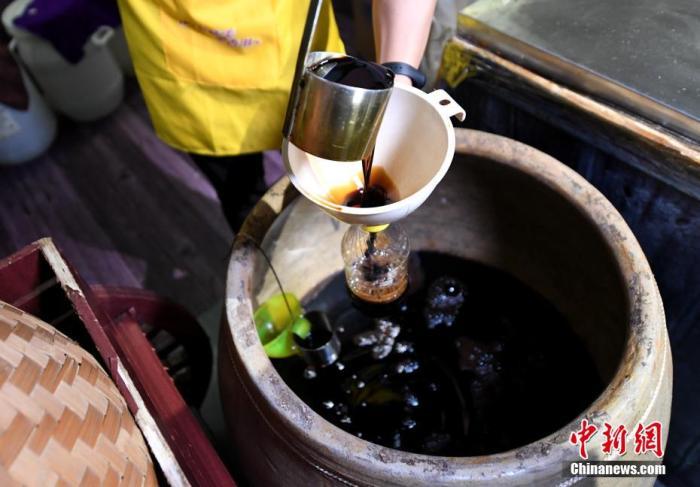 圖為工人將做好的醬油進(jìn)行罐裝。 王東明 攝