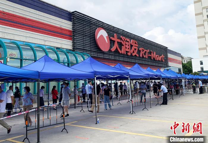 民眾排著長長的隊(duì)伍，在工作人員的指引下，等待進(jìn)入超市購物。　崔佳明 攝