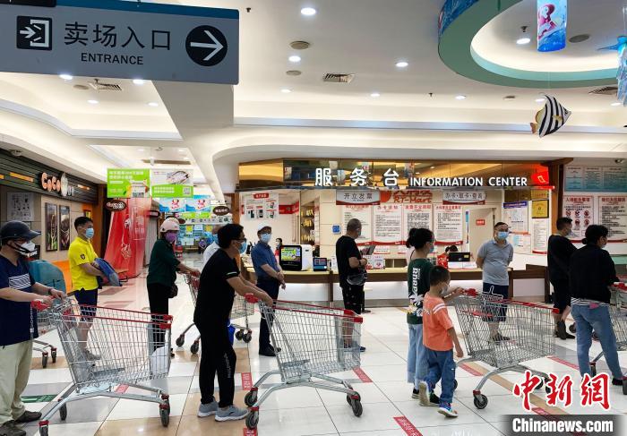 民眾戴著口罩，有序排隊(duì)，等待進(jìn)入超市購物?！〈藜衙?攝