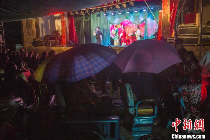 民眾在雨中觀看蒲劇?！∥淇〗?攝