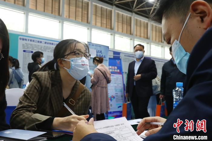 圖為南昌大學前湖校區(qū)校園招聘活動現(xiàn)場，一名大學生正在求職現(xiàn)場填寫報名表。　劉占昆 攝