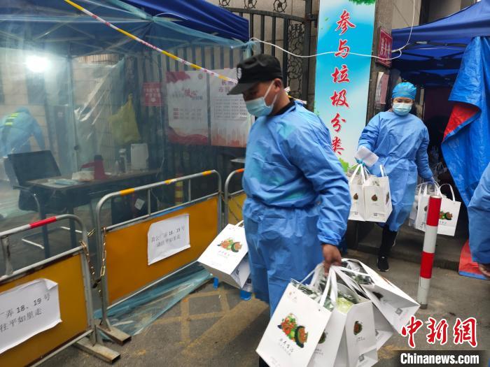杭州一封閉管理小區(qū)，工作人員為居民配送愛心蔬菜。　王逸飛 攝