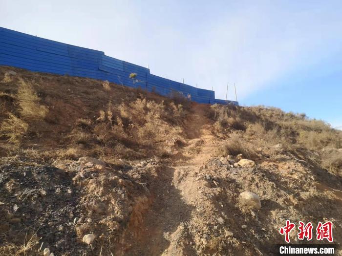 與事發(fā)盜采點隔路相對的村西處，一大片場地被圍欄圍住，有的大坑未來得及填埋。　李庭耀 攝
