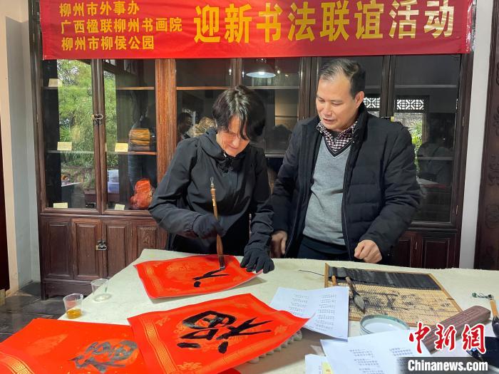 圖為一名英國(guó)人體驗(yàn)寫(xiě)春聯(lián)?！×周?攝