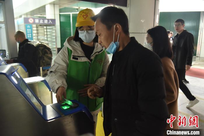 圖為志愿者協(xié)助乘客?！№n毅 攝