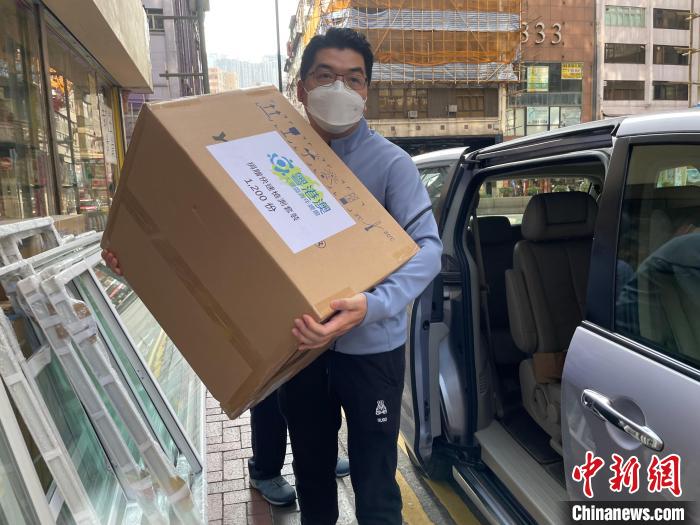 圖為吳學(xué)明搬運1200份快速檢測套裝及500多個口罩，捐贈給開平樓崗?fù)l(xiāng)會?！∈茉L者供圖