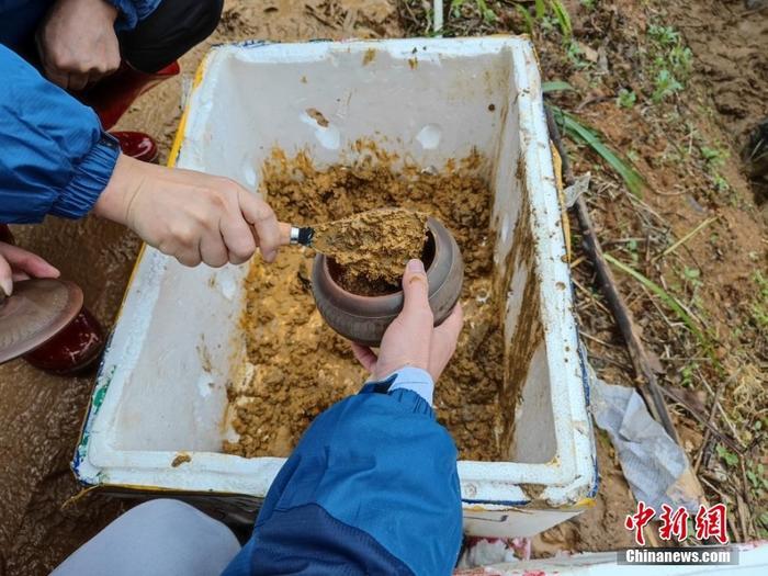 乘客家屬使用陶罐帶現(xiàn)場泥土回家。<a target='_blank' href='/'>中新社</a>記者 王以照 攝