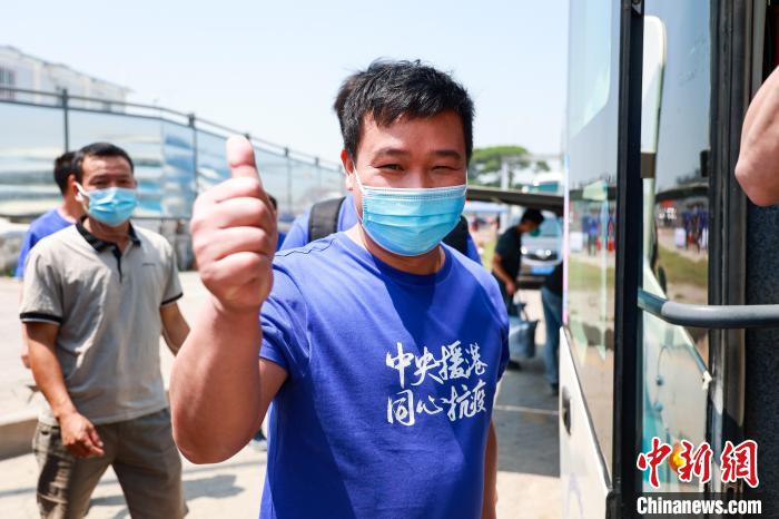 建設(shè)者們身穿文化衫，帶著燦爛的笑容離開(kāi)駐地?！≠Z凱 攝