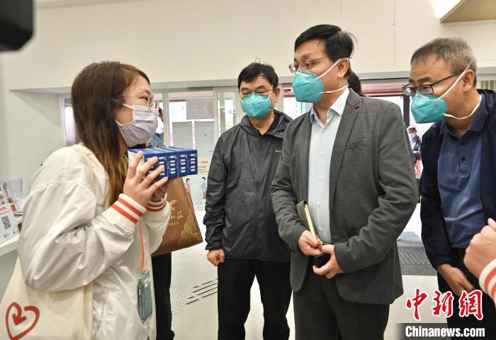 內(nèi)地疫情防控專家到訪深水埗地區(qū)康健中心。中心職員向?qū)＜医榻B向長者免費(fèi)派發(fā)快速抗原測試套裝的工作。　香港特區(qū)政府新聞處供圖