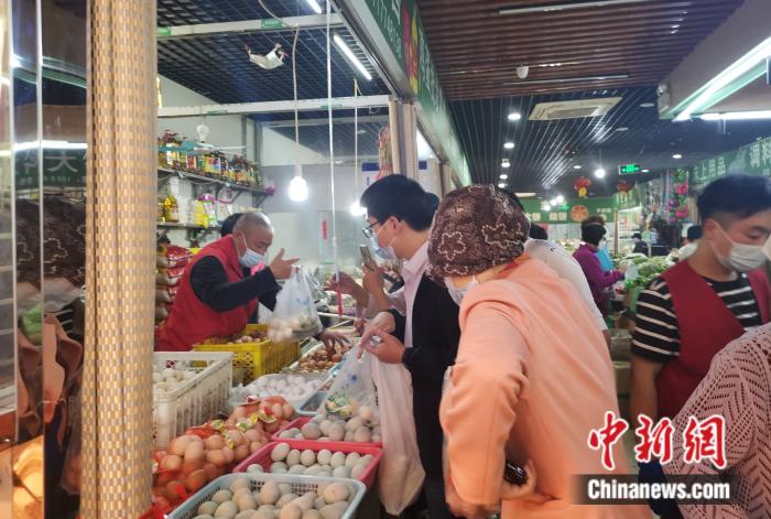 北京豐臺區(qū)某菜市場內(nèi)，不少人在購買雞蛋。 中新財經(jīng)記者 謝藝觀 攝