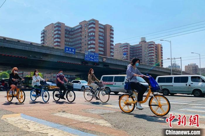 5日，北京東三環(huán)附近正騎單車出行的市民。