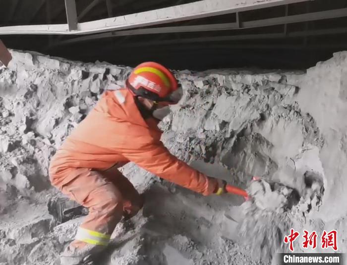 一名消防員單腿跪在粉煤灰堆上搜救被困人員?！↓R帥 攝