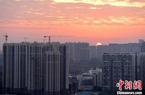 資料圖：城區(qū)一角，太陽(yáng)正從東方升起。<a target='_blank' href='/'>中新社</a>記者 劉忠俊 攝