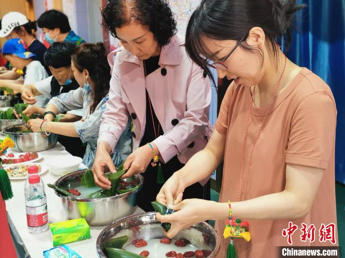 在寧港澳臺(tái)同胞與社區(qū)居民一起包粽子。　寧夏港澳臺(tái)辦 供圖