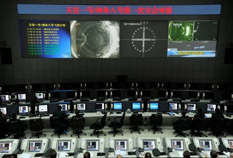 2011年11月3日凌晨，在酒泉衛(wèi)星發(fā)射中心指控大廳，技術(shù)人員通過大屏幕觀看天宮一號與神舟八號飛船對接全程。（圖源：央視新聞）