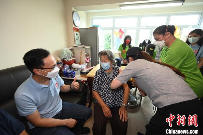 聶德權(左一)鼓勵一位居于香港坪洲的80多歲長者(左二)接種第二劑新冠疫苗?！∠愀厶貐^(qū)政府新聞處供圖