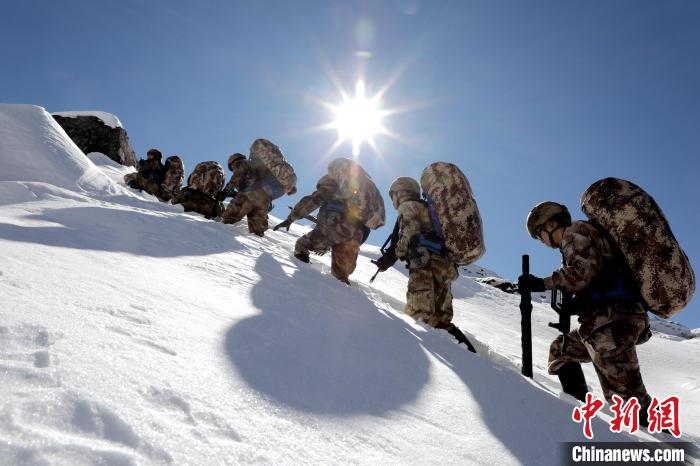 圖為巡邏官兵翻越雪山?！●R軍 攝