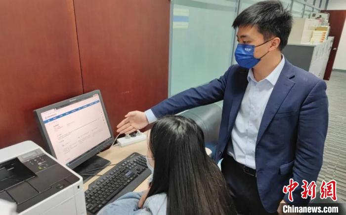 圖為廈門銀行員工指導(dǎo)臺商通過金服云平臺申請“臺企快服貸”?！＄娦?攝
