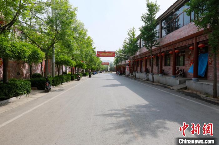 前南峪村干凈整潔、綠樹成蔭的街道，路兩側(cè)是村民住的二層樓房?！堸i翔 攝