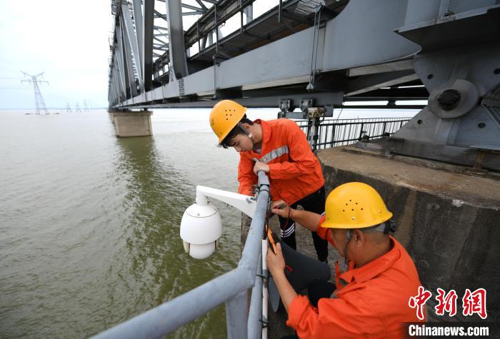 6月24日，南鐵九江橋工段的橋梁工正在九景衢鐵路鄱陽(yáng)湖大橋上對(duì)監(jiān)控?cái)z像頭進(jìn)行檢修?！『鷩?guó)林 攝