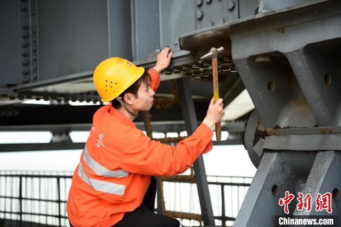 6月24日，南鐵九江橋工段的橋梁工正在九景衢鐵路鄱陽(yáng)湖大橋上對(duì)高強(qiáng)度螺栓進(jìn)行檢查更換?！?黃旸 攝