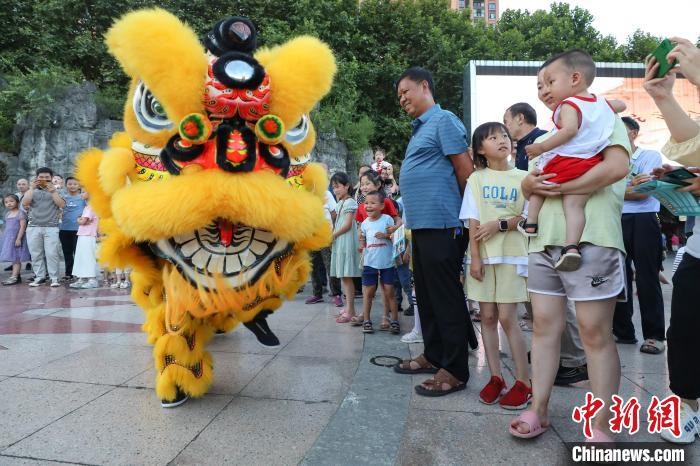賴翊凡(獅頭)與李洪江配合在縣城詩鄉(xiāng)廣場練習(xí)舞獅吸引市民觀看?！■暮陚?攝