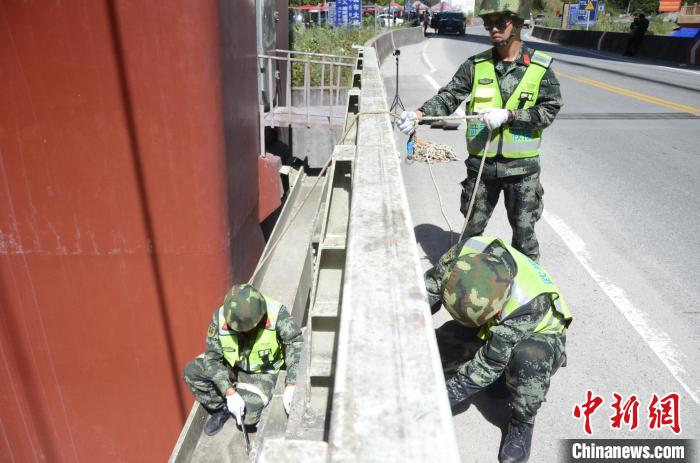 圖為武警官兵對通麥特大橋進(jìn)行養(yǎng)護(hù)?！∫笥苋?攝