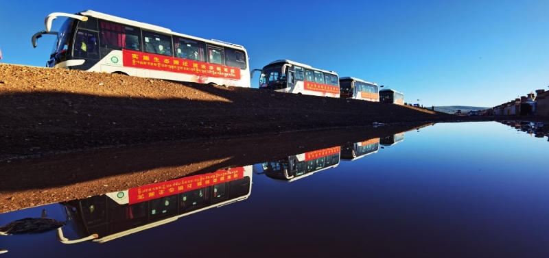 在西藏那曲市雙湖縣多瑪鄉(xiāng)拍攝的整裝待發(fā)的車隊，客車載著牧民前往位于山南市貢嘎縣的森布日安置點(2022年7月19日攝)。新華社記者 沈虹冰 攝
