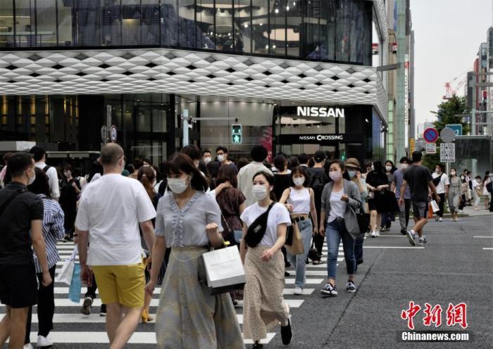 資料圖：日本當(dāng)?shù)孛癖娕宕骺谡肿哌^東京街頭。 <a target='_blank' href='/'>中新社</a>記者 呂少威 攝
