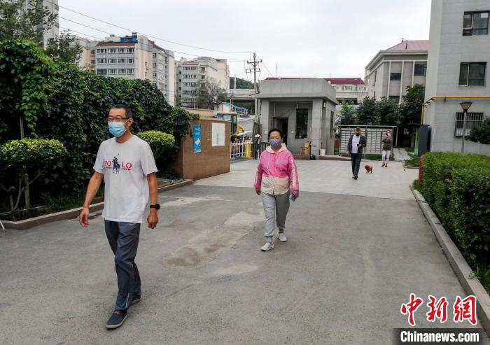 烏魯木齊市沙依巴克區(qū)國道社區(qū)，市民保持距離在小區(qū)內(nèi)散步?！＄娦?攝