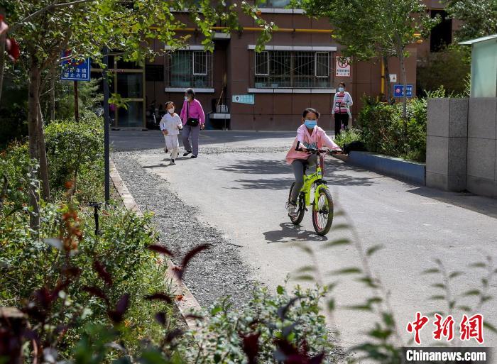 烏魯木齊市水磨溝區(qū)七道灣東街南社區(qū)，居民下樓在小區(qū)內(nèi)活動?！＄娦?攝