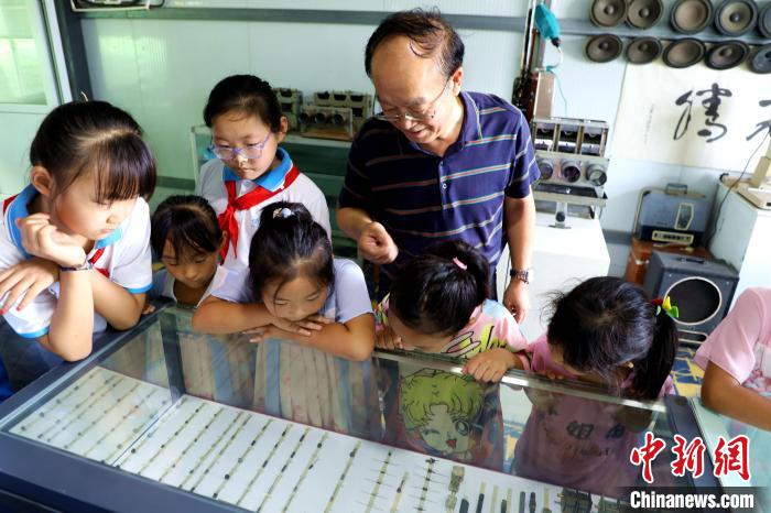 圖為肖光合正在給孩子們介紹收音機上的零件和電路原理?！∩筹w 攝