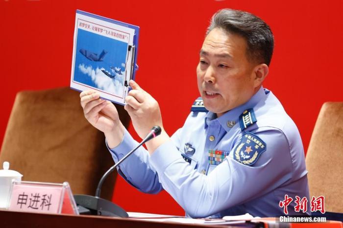 圖為申進科大校在發(fā)布會上展示運油-20、殲-20、殲-16三機同框照。 <a target='_blank' href='/'>中新社</a>記者 富田 攝