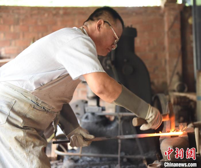 王二兵在對燒制的劍進(jìn)行鍛打。　高占峰 攝