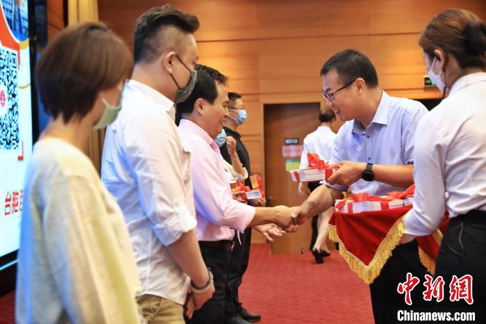 8月25日，北京市臺辦向臺胞代表贈送《臺胞百問》手冊?！±钛┓?攝