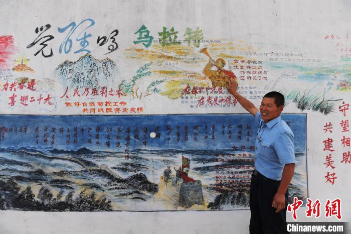 圖為謝建民介紹自己出的墻報。　胡東育 攝