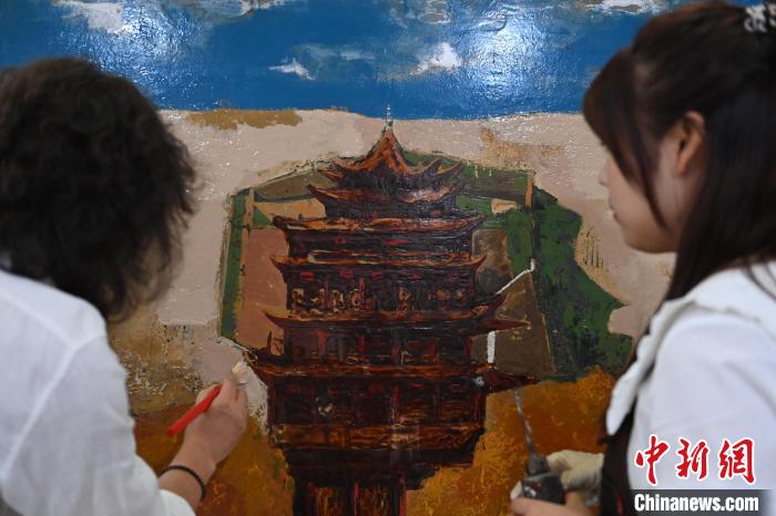 圖為劉志剛與學(xué)生進(jìn)行敦煌元素漆畫創(chuàng)作?！±顏嘄?攝