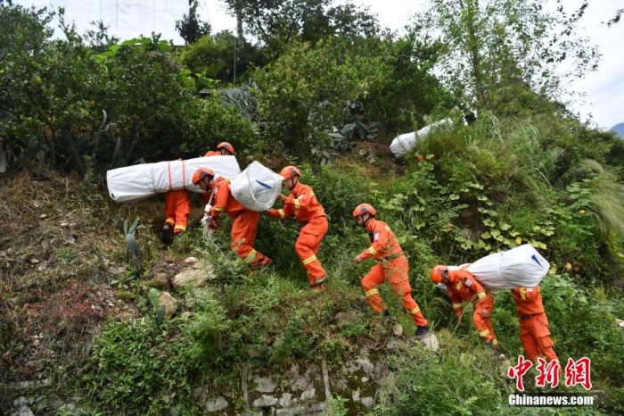資料圖：消防員徒步運送帳篷物資。 張浪 攝