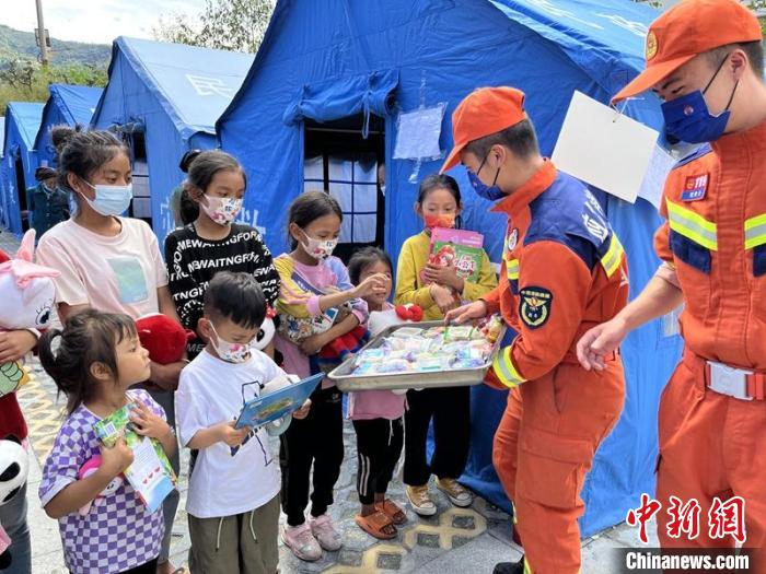 臨時(shí)安置點(diǎn)消防員給村民和孩子送上中秋月餅?！埼?攝