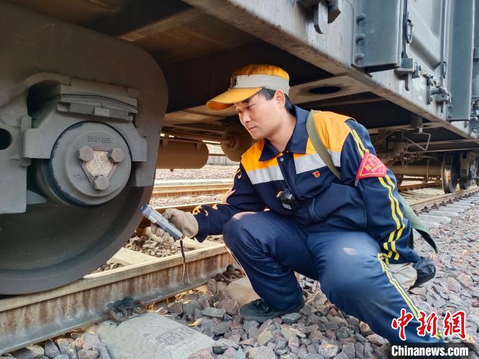 圖為張建亮在檢查車輛軸承溫度?！≈炜△?攝
